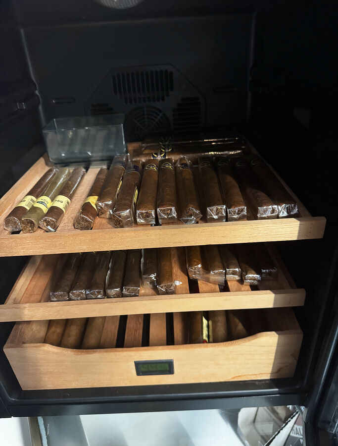 Premium cigars resting on cedar humidor trays